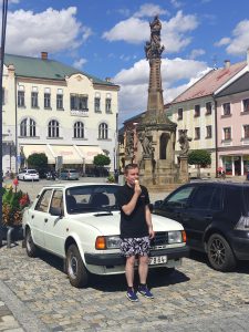 Pavel standing at the front of Škoda 120L, eating an ice cream