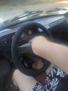 Pavel vacuums behind the steering wheel